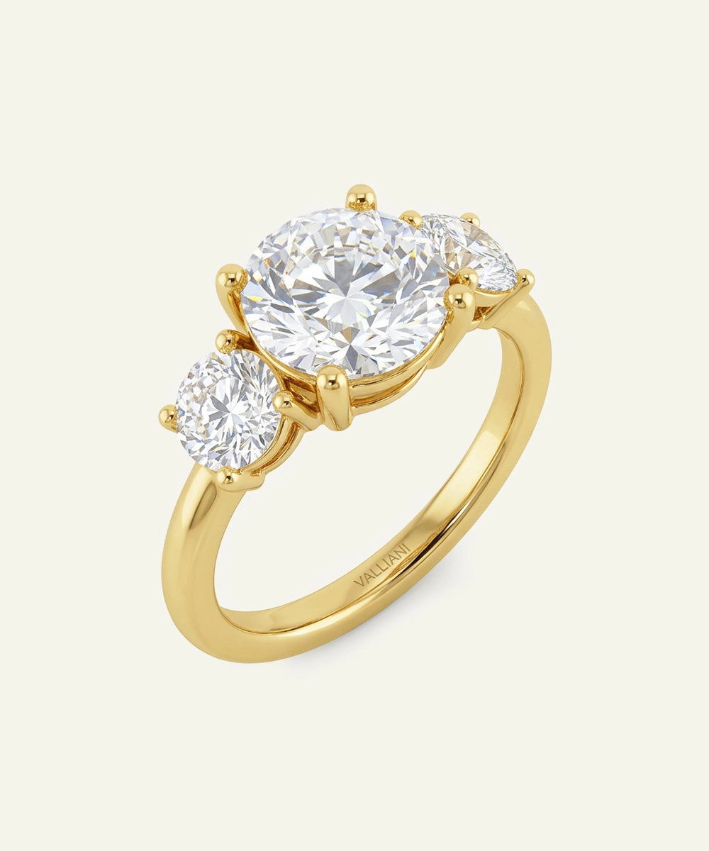 Gold ring with three diamonds on a white background