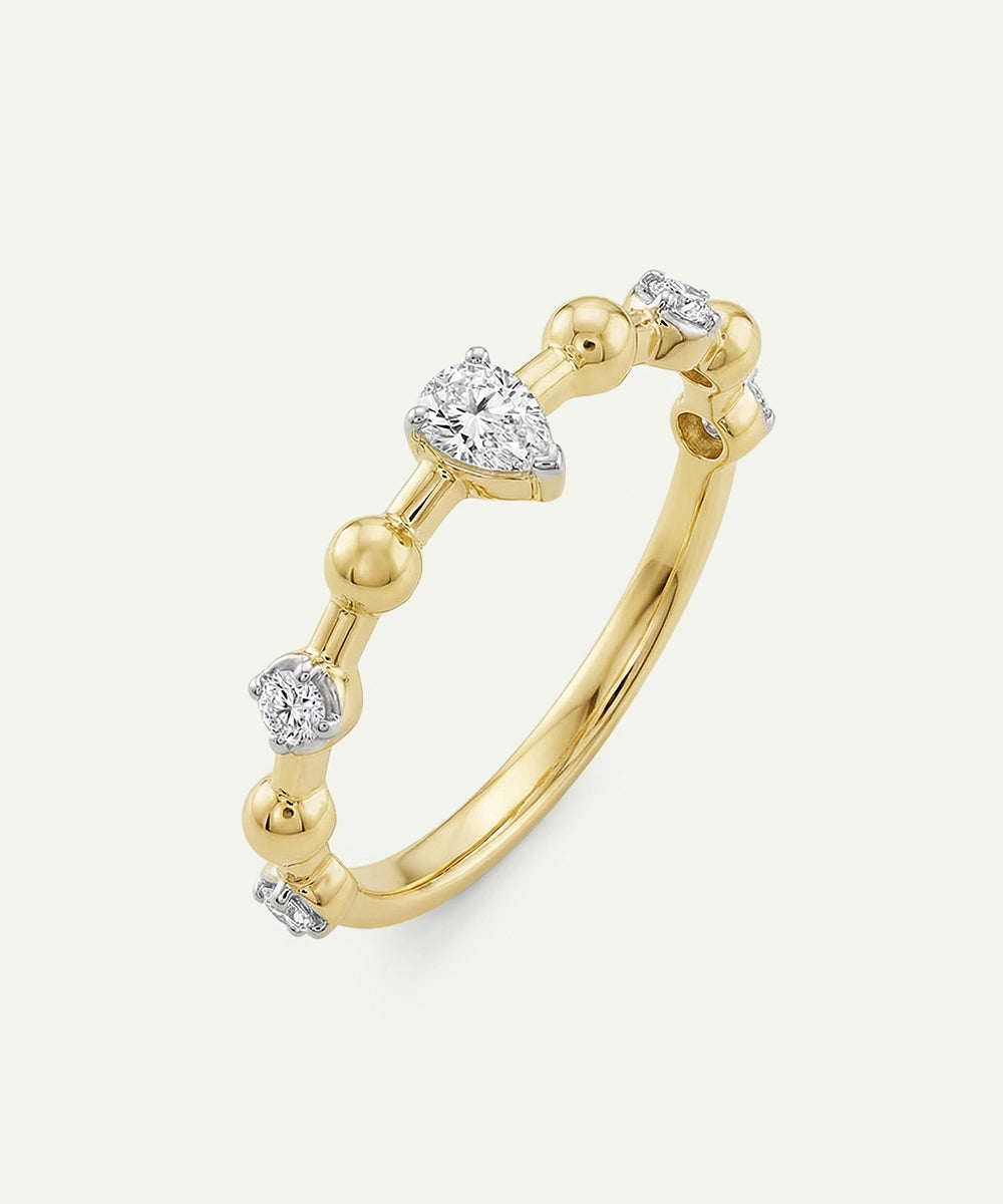 Gold ring with diamond accents on a light gray background