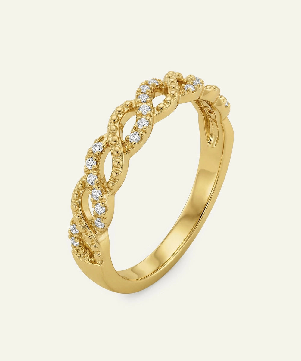 Gold ring with diamond accents on a light beige background