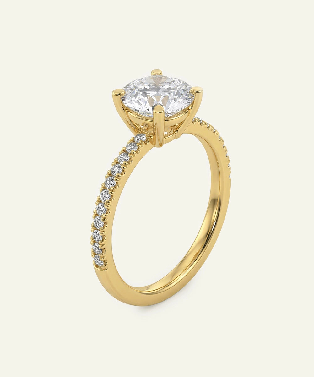 Gold ring with a large diamond and smaller diamonds on the band against a white background