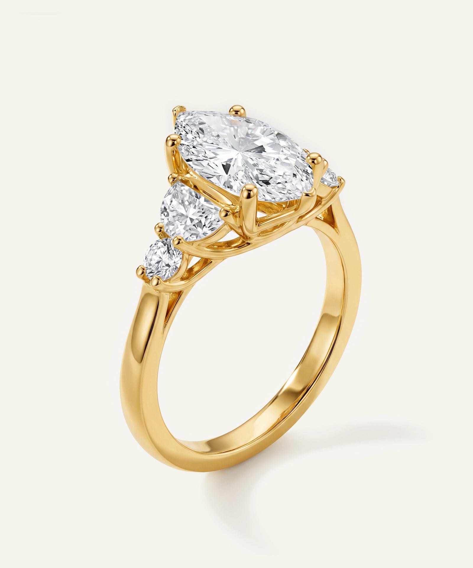 Gold ring with a pear-shaped diamond on a white background