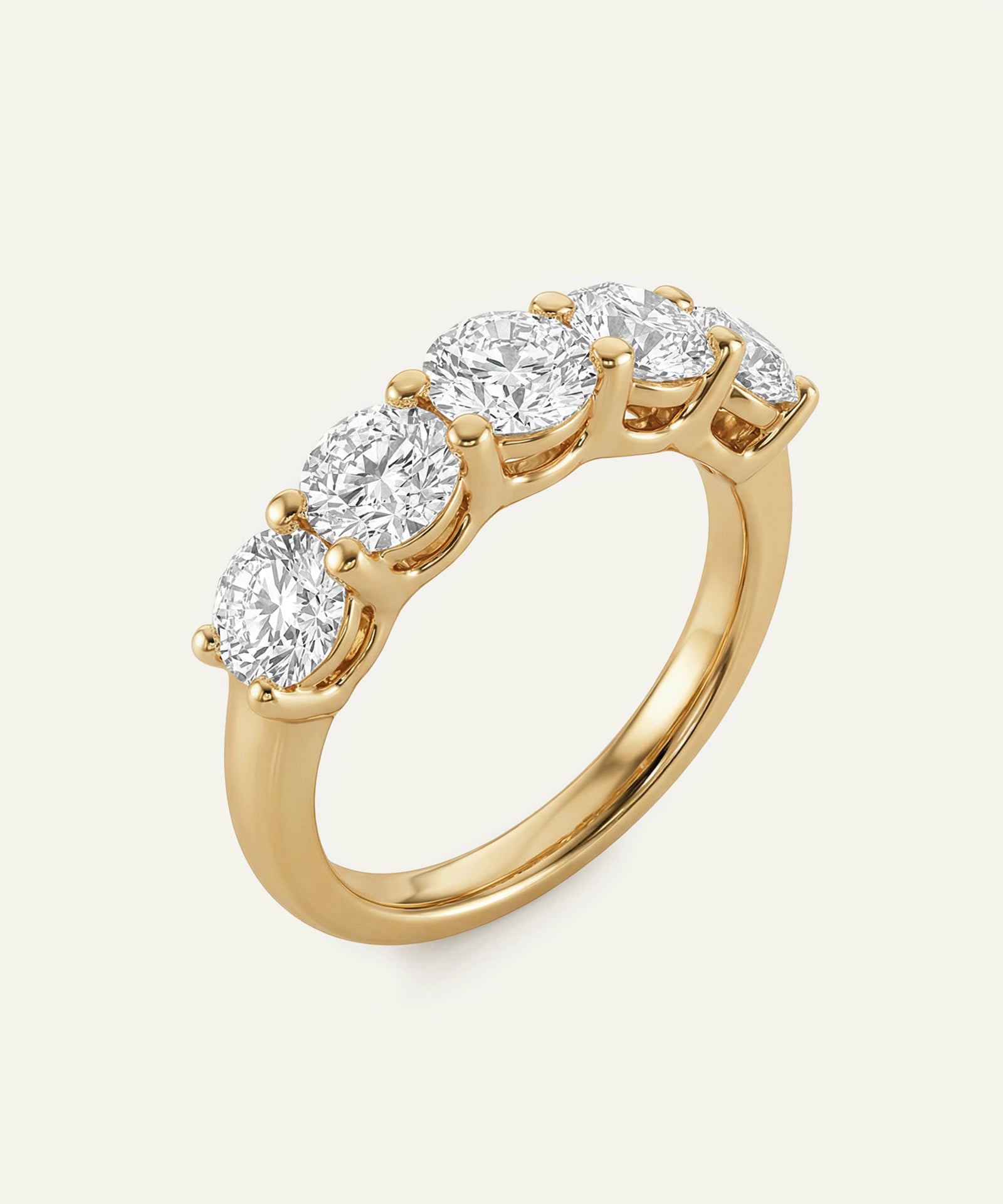 Gold ring with five diamonds on a light beige background