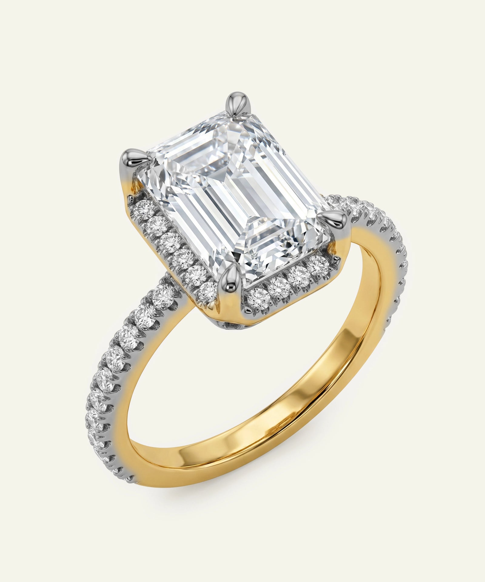Gold and diamond ring with a large emerald-cut diamond on a white background