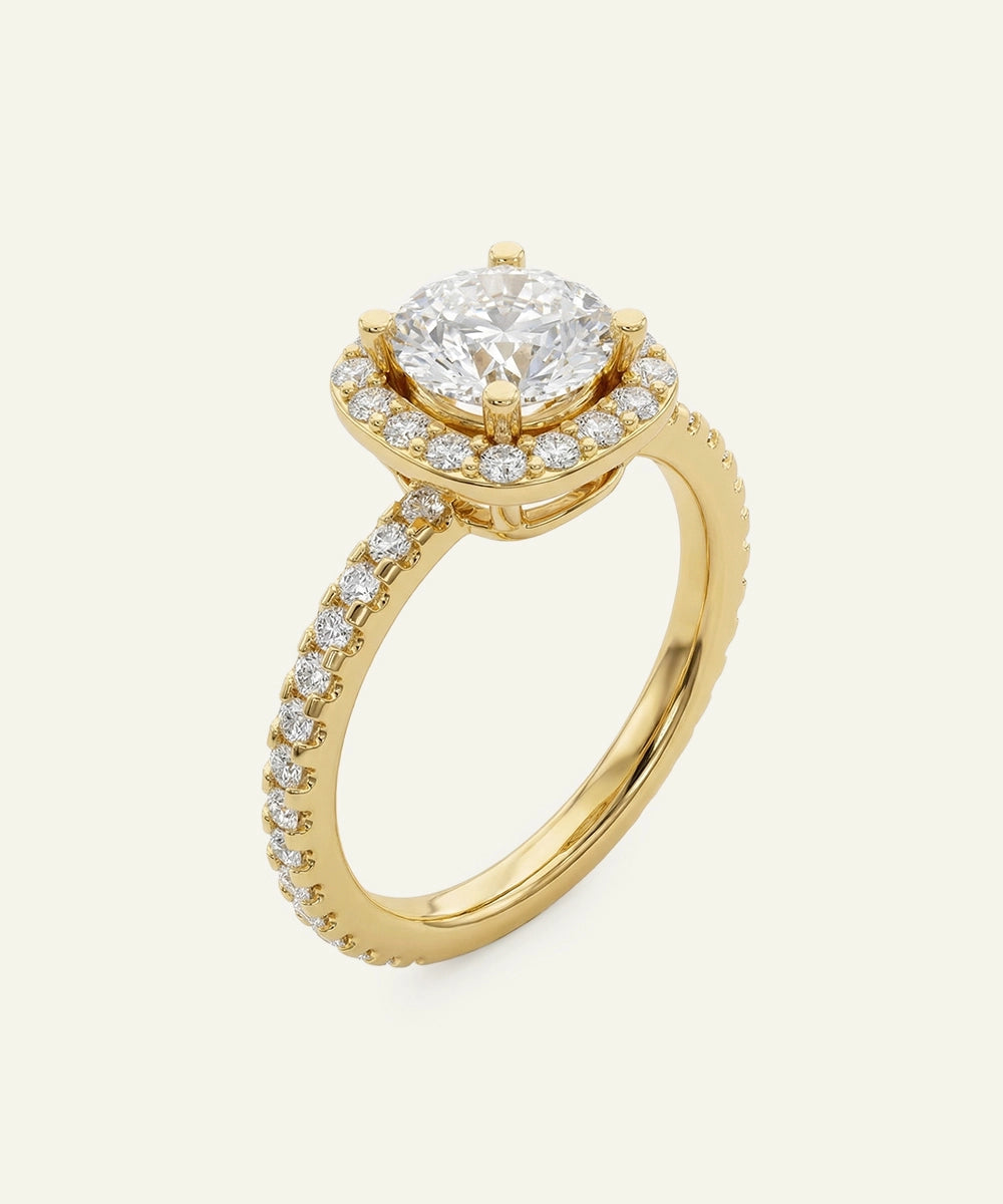 Gold ring with a large diamond and smaller diamonds on the band against a white background