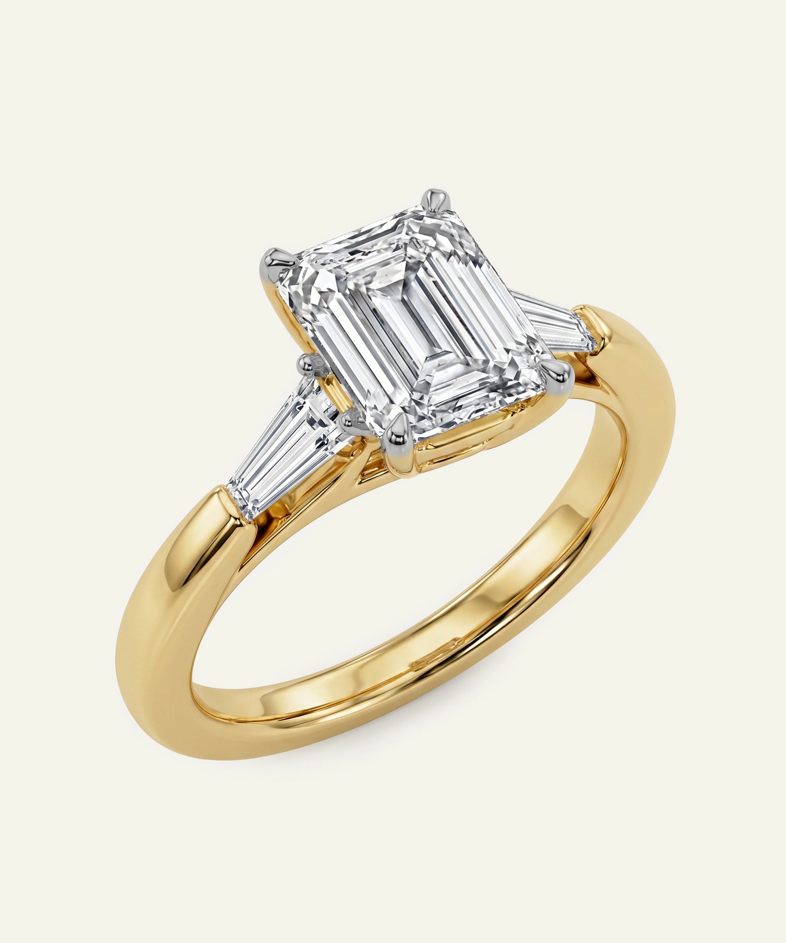 Gold ring with emerald-cut diamond on a white background
