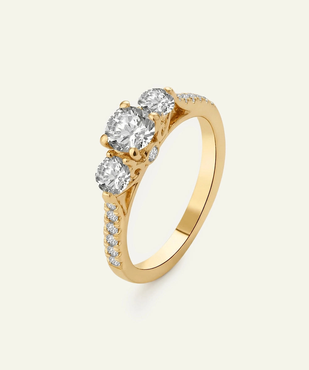 Gold ring with three diamonds on a light gray background