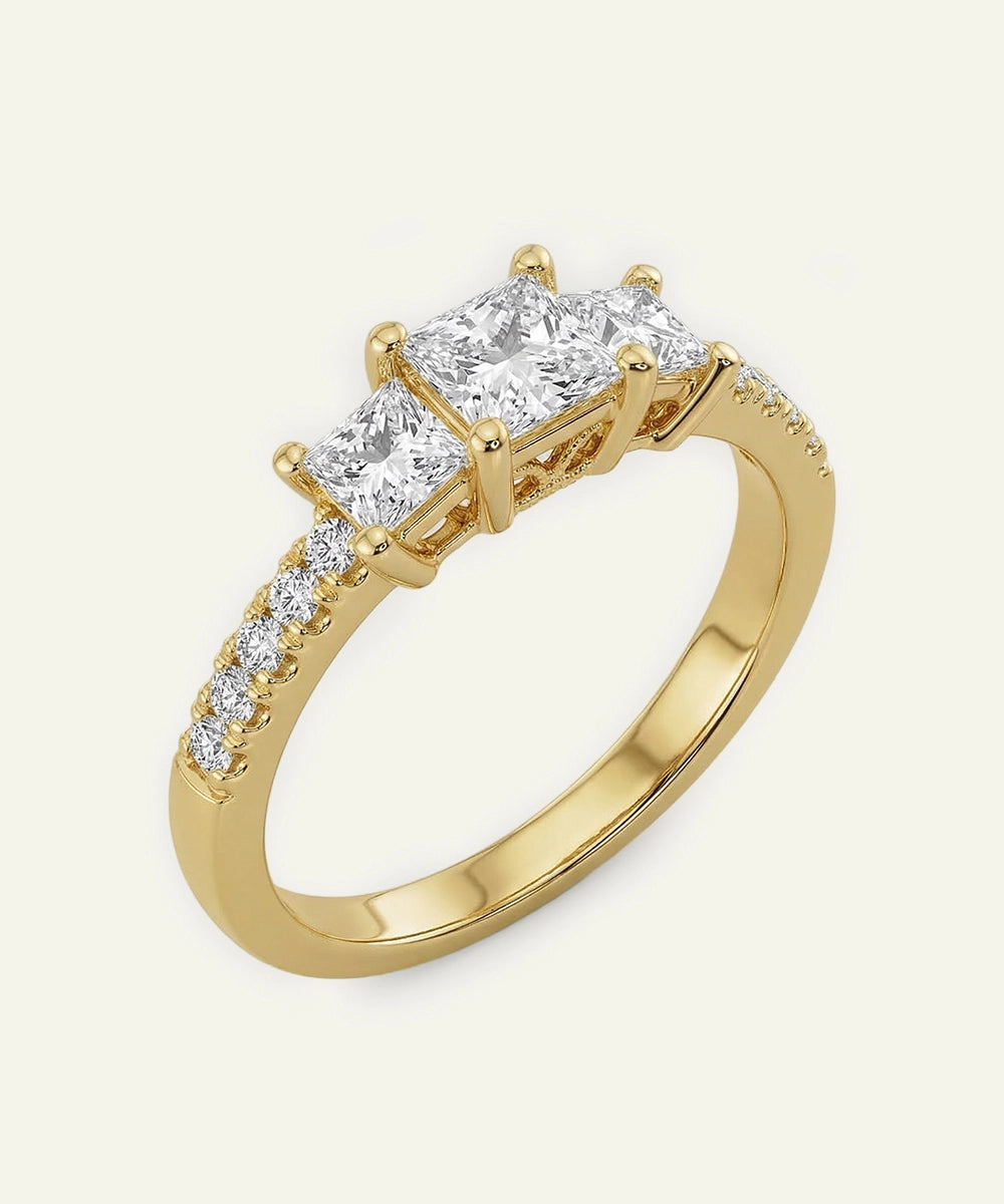 Gold ring with three diamond stones on a white background