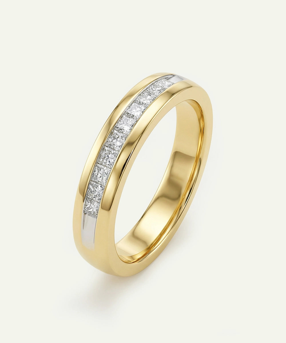 Gold ring with embedded diamonds on a light beige background