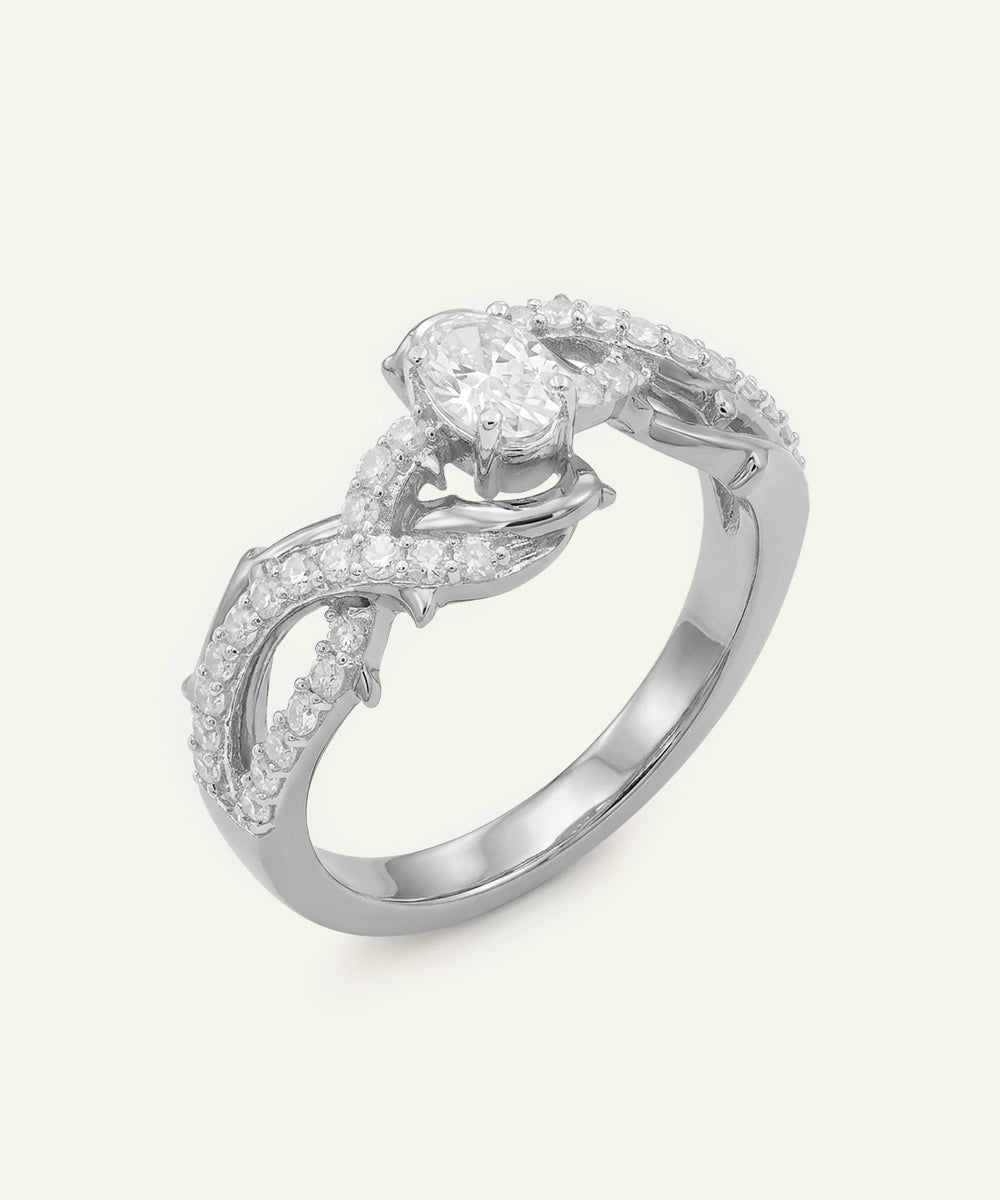 Silver ring with diamond accents on a light gray background