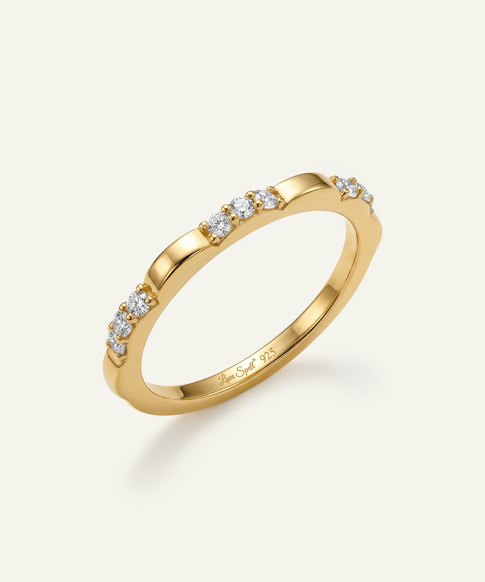 Gold ring with diamonds on a light beige background