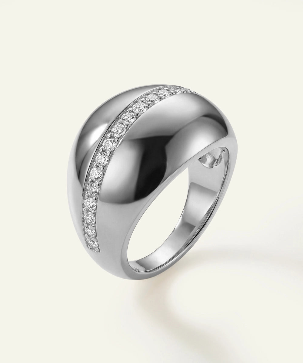 Silver ring with small diamonds on a light gray background