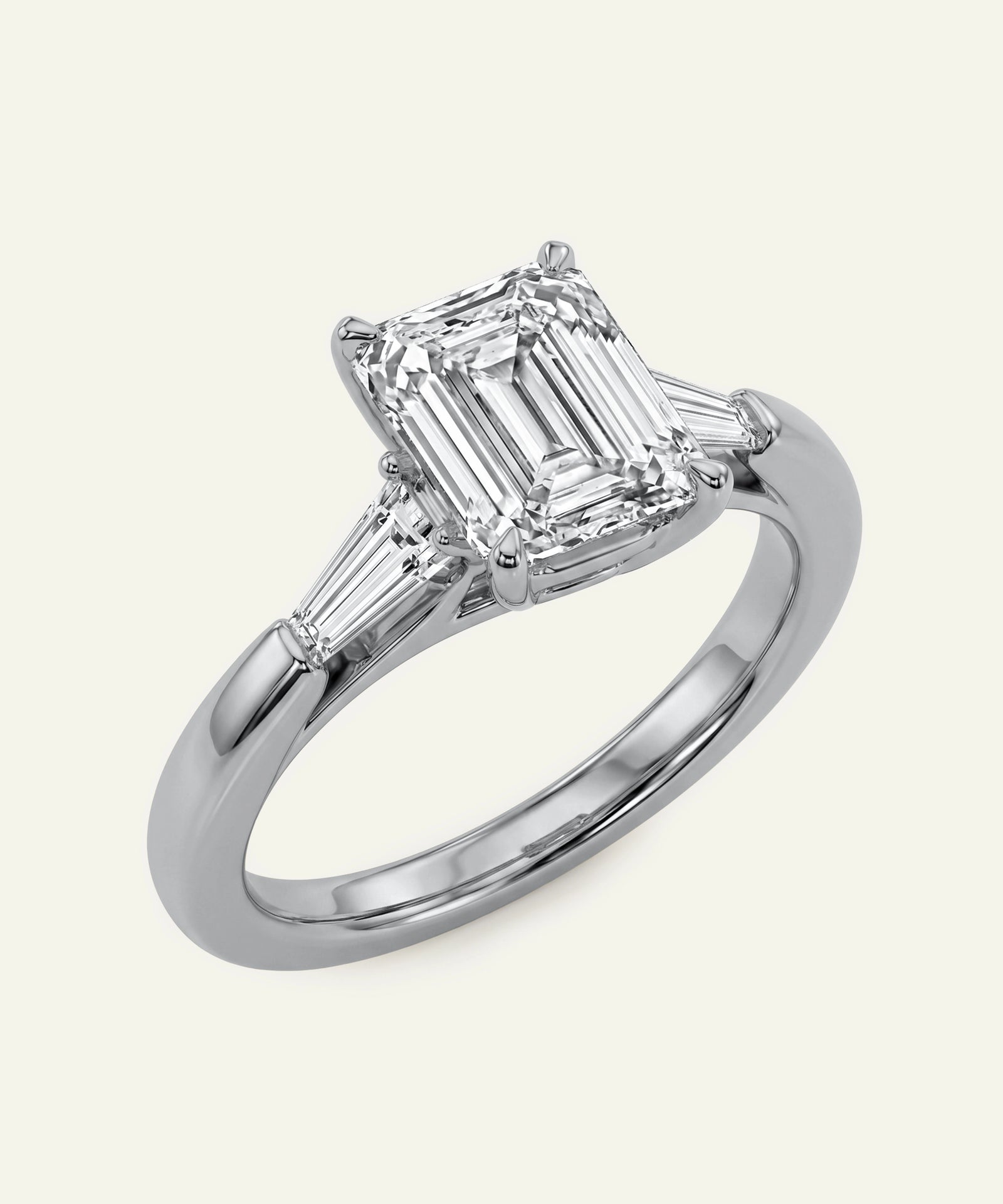 Diamond ring with emerald-cut center stone and baguette side stones on a white background