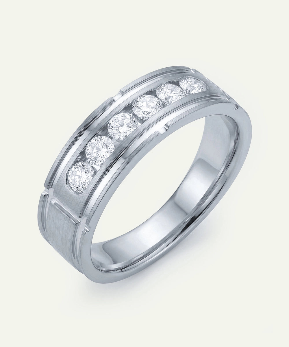 Silver ring with embedded diamonds on a light gray background