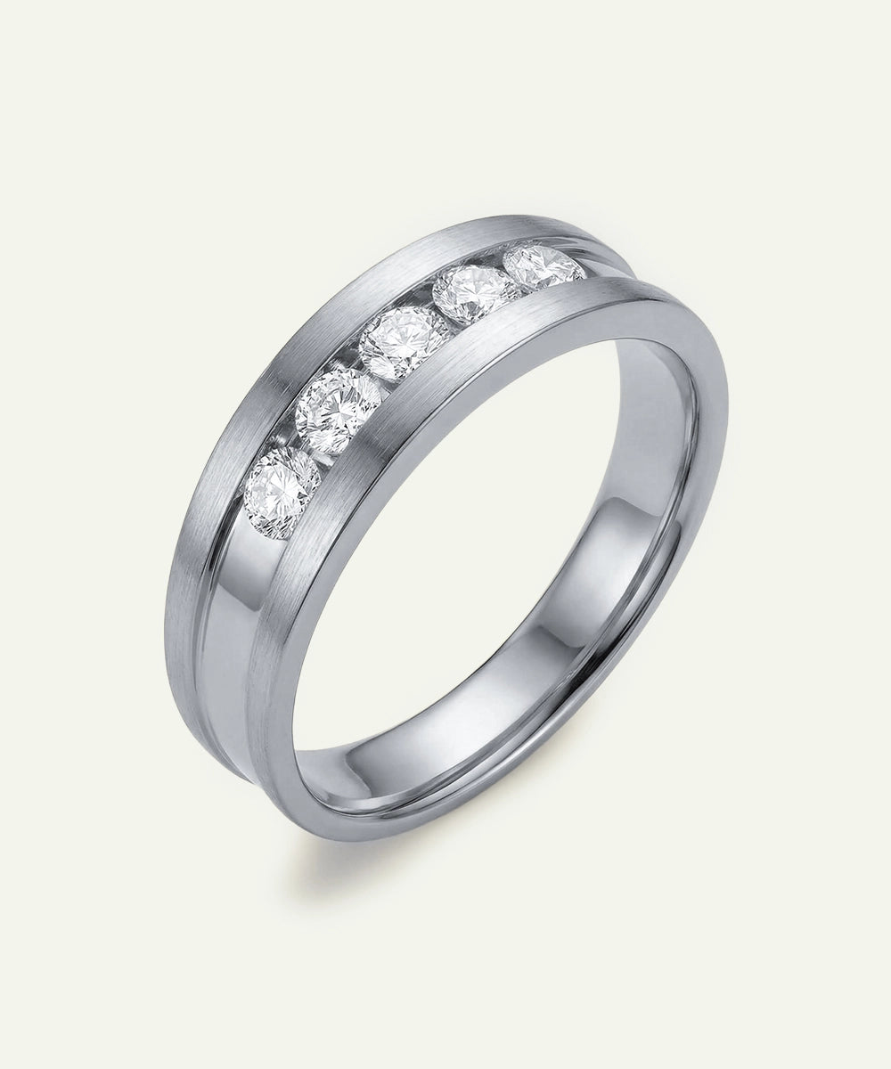 Silver ring with embedded diamonds on a light gray background
