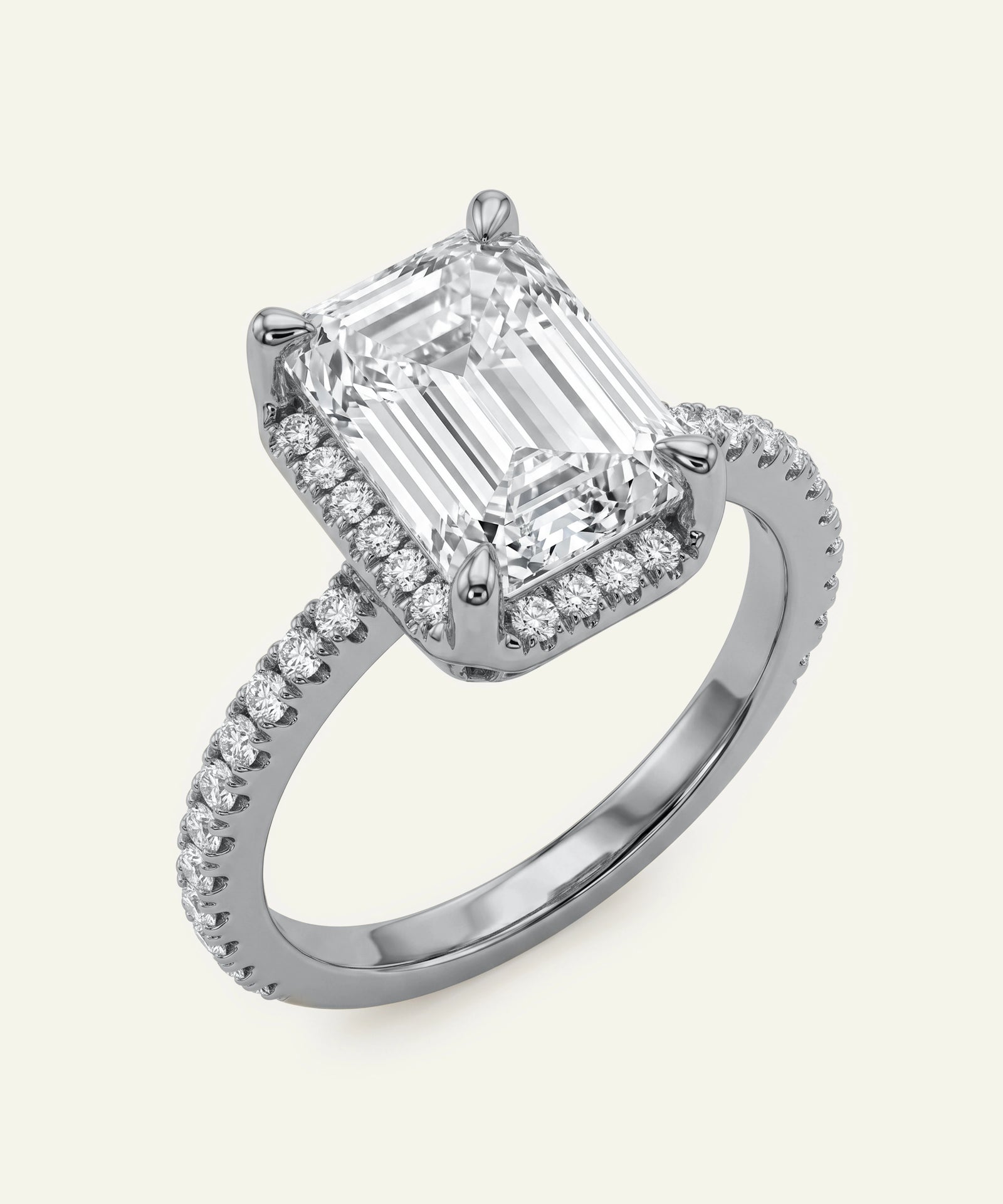 Diamond ring with emerald-cut center stone and smaller diamonds on a white background