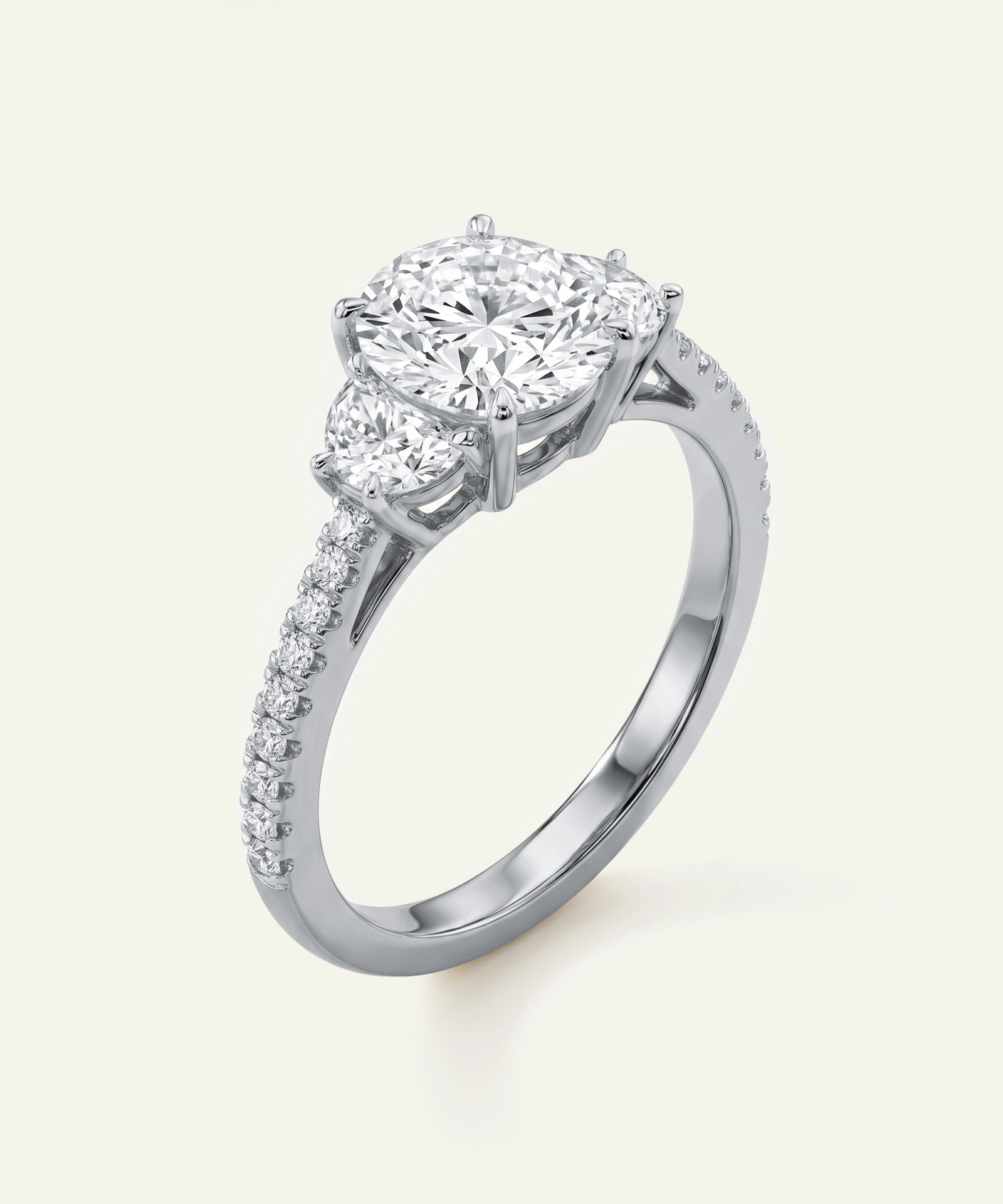 Diamond ring with two prominent diamonds and a smaller one on a light background