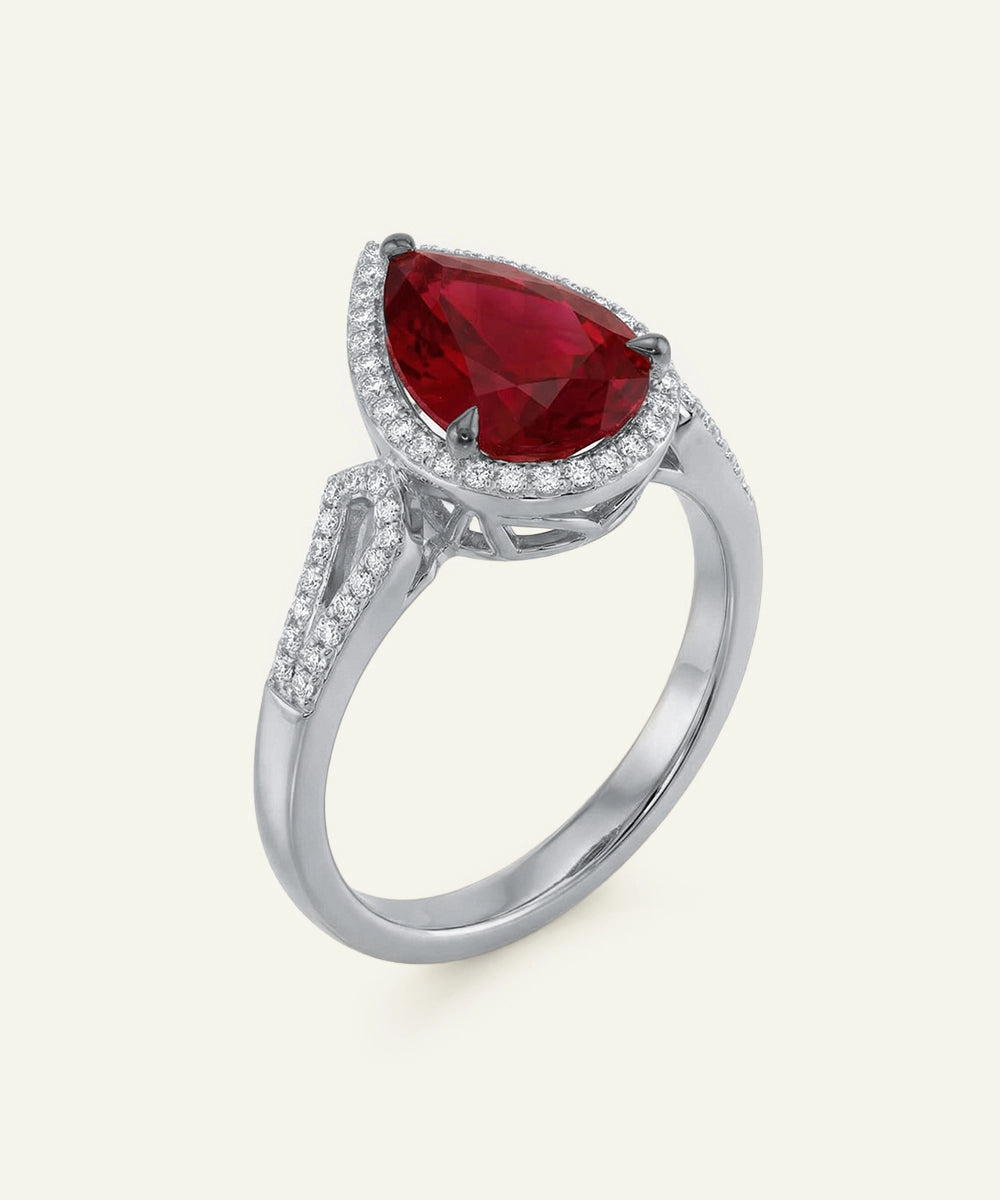 Silver ring with a red gemstone on a white background