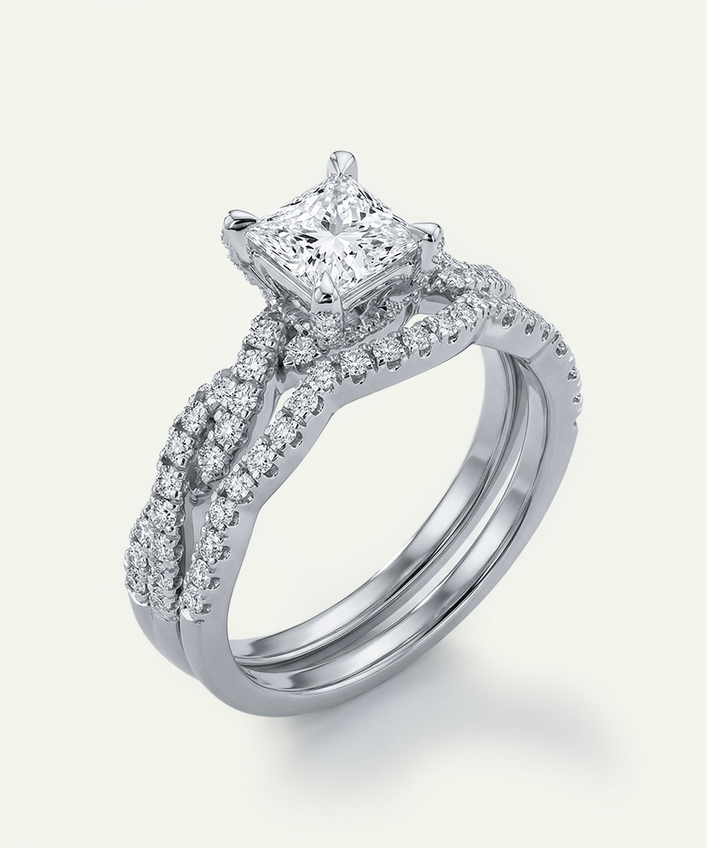Diamond ring with a central princess-cut diamond and smaller diamonds on a white background