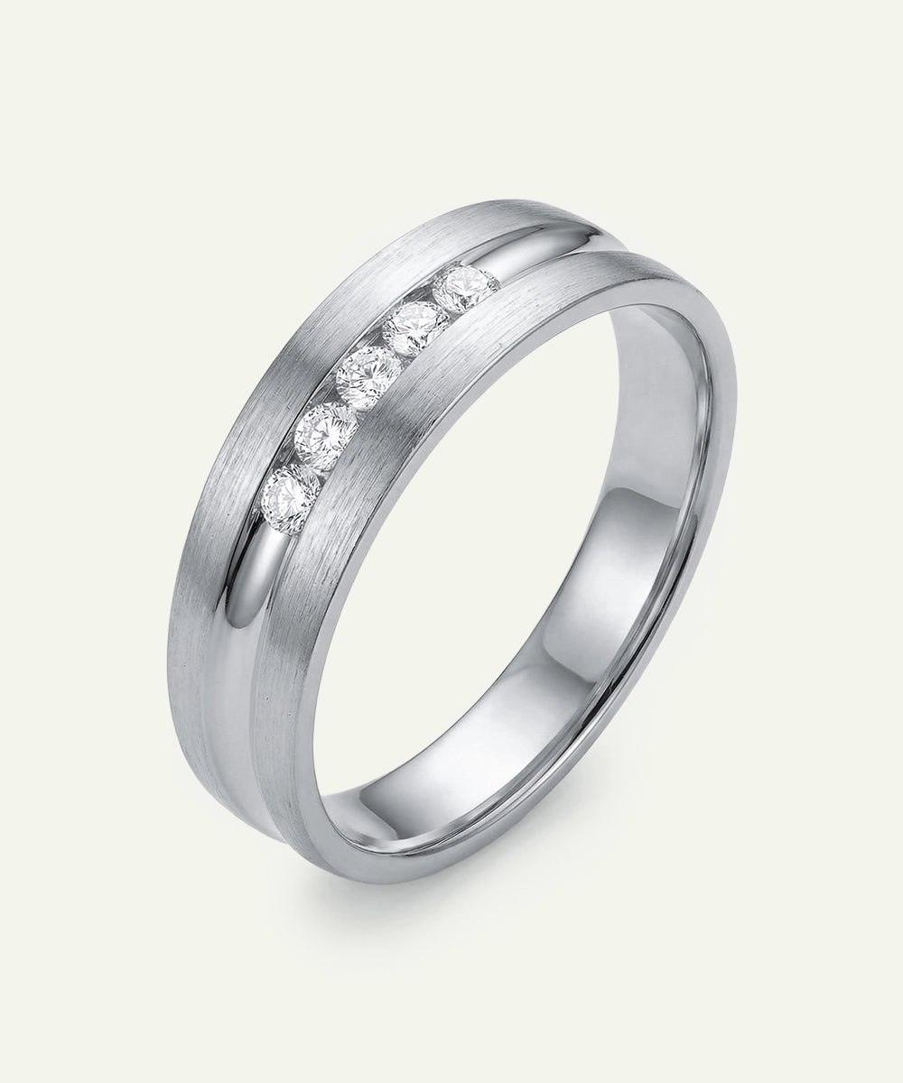 Silver ring with embedded diamonds on a light gray background