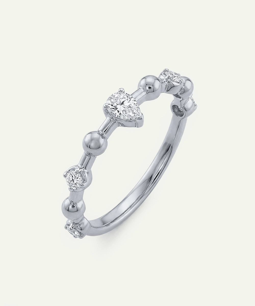 Silver ring with diamond accents on a light gray background