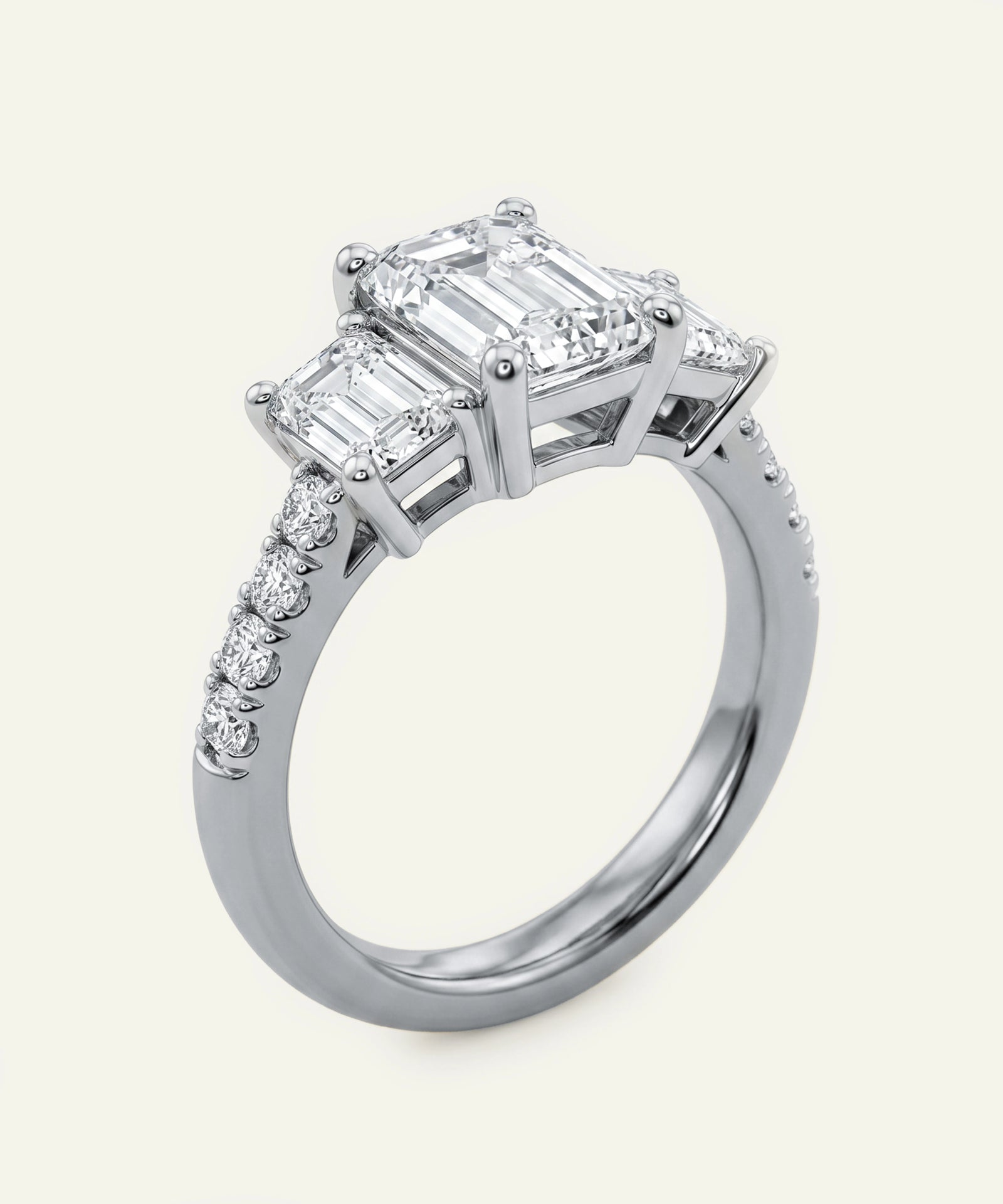 Diamond ring with emerald-cut center stone and smaller diamonds on a white background