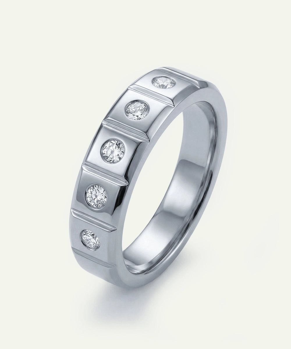 Silver ring with embedded diamonds on a light gray background