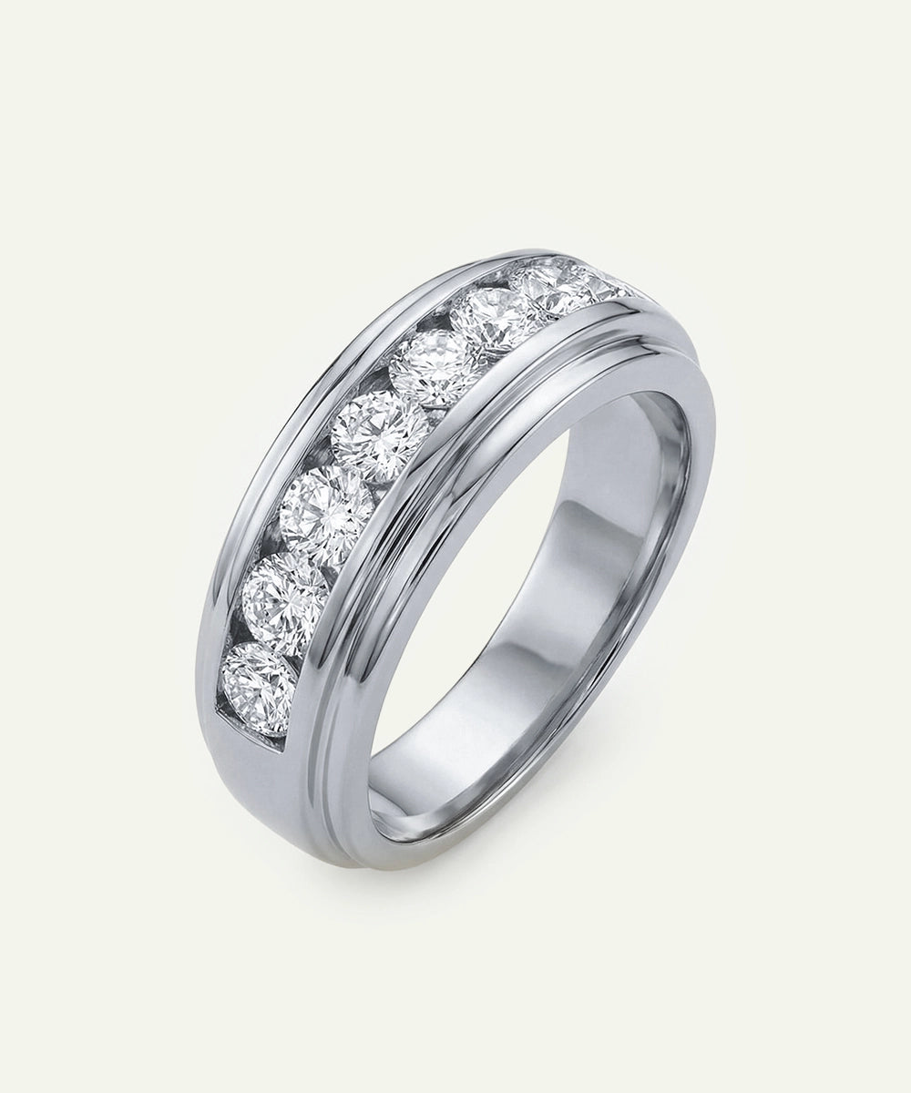 Silver ring with embedded diamonds on a light gray background
