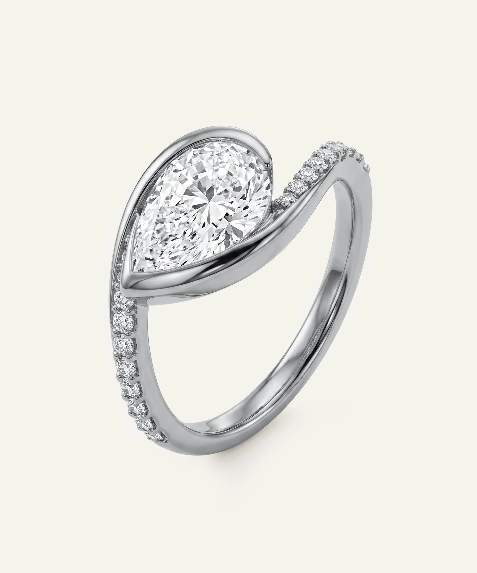 Diamond ring with a pear-shaped center stone on a white background