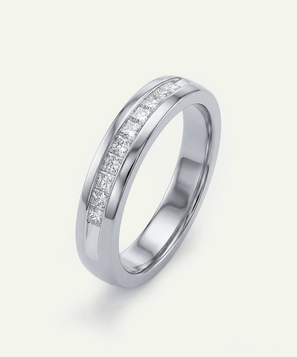 Silver ring with embedded diamonds on a light gray background