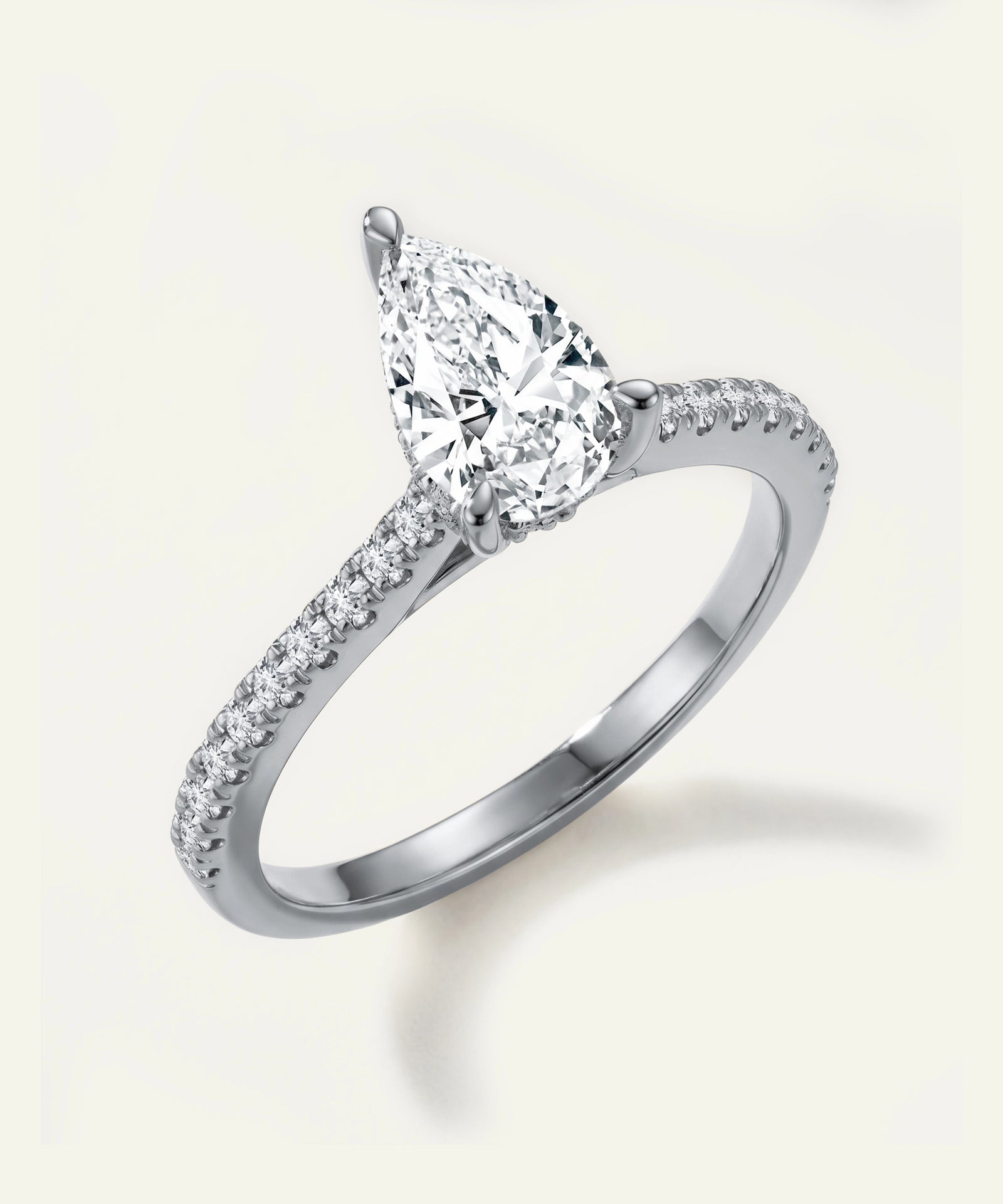 Diamond ring with a pear-shaped center stone on a light background