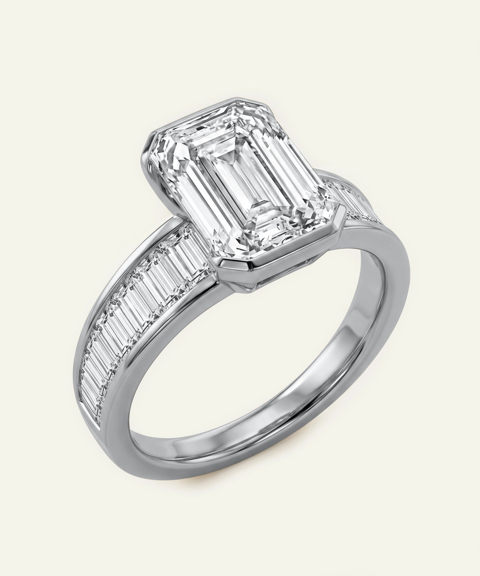 Diamond ring with emerald-cut center stone and baguette side stones on a white background