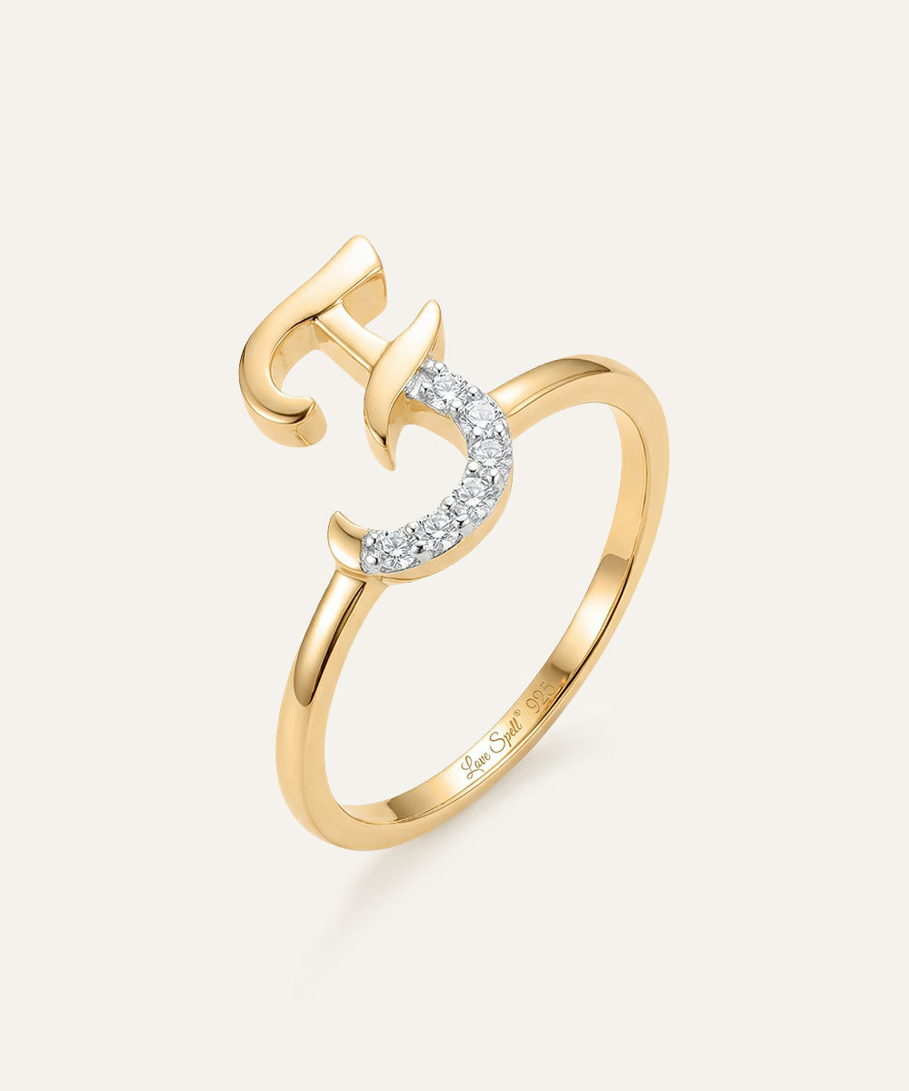 Gold ring with a unique design on a light gray background