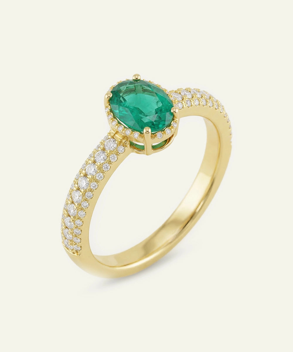 Gold ring with a green gemstone and diamond accents on a white background