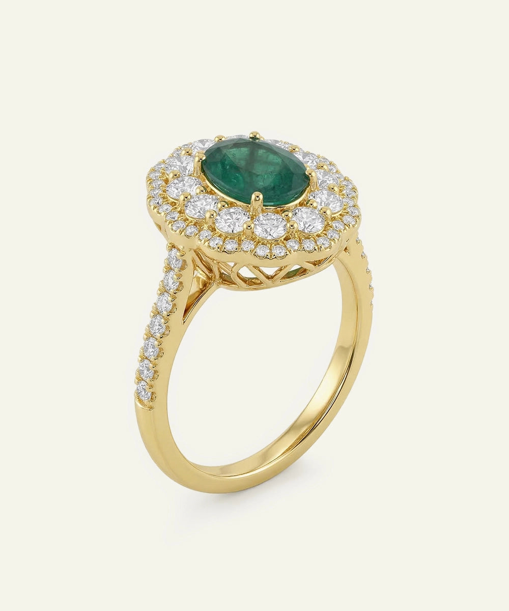 Gold ring with a green gemstone and diamond accents on a white background
