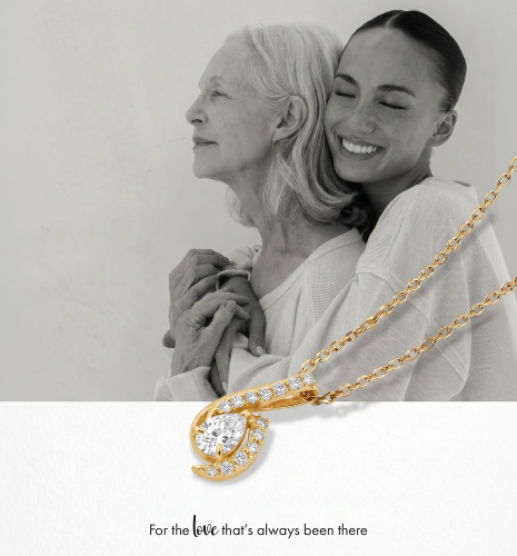 Gold “Loved” pendant necklace with diamond circle and white gold diamond heart rings displayed on red velvet